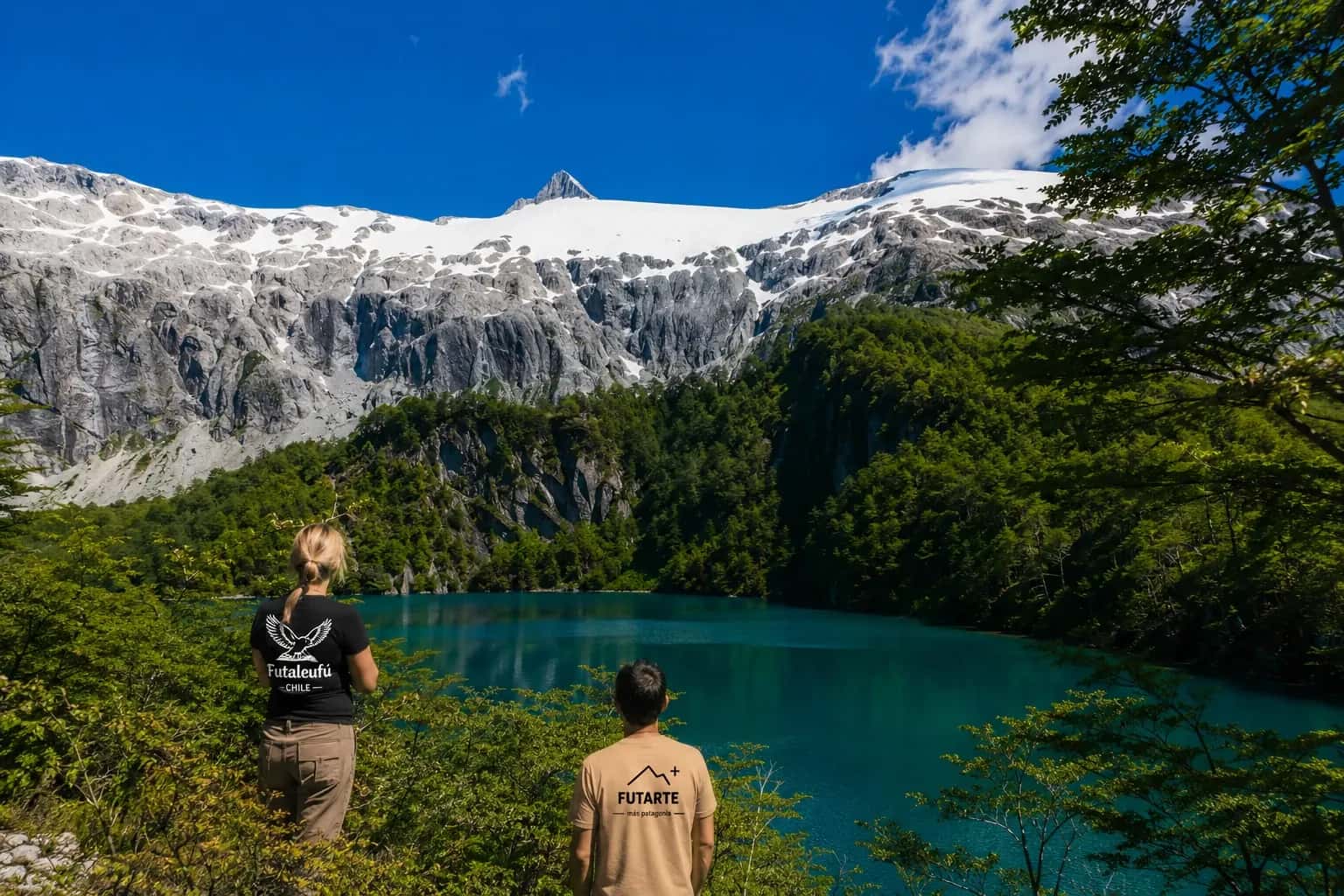 Personas con prendas Futarte frente al lago y las montañas nevadas de Futaleufú, Chile